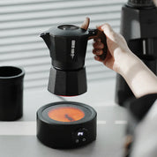 Elektrischer Kaffeewärmer in Schwarz erhitzt eine Mokkakanne in der Anwendung