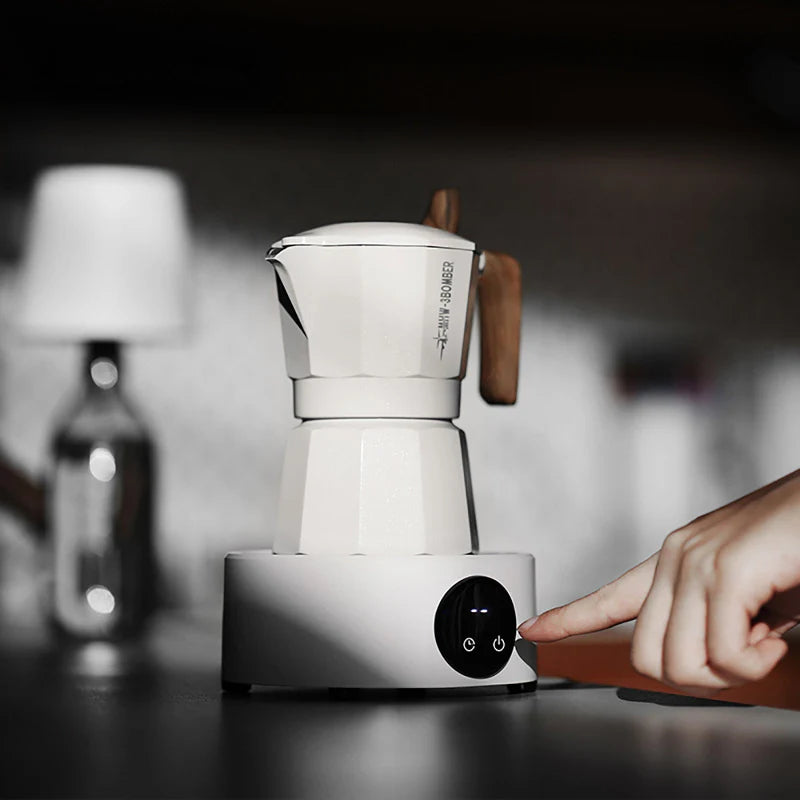 Weißer elektrischer Kaffeewärmer mit Mokkakanne bei der Anwendung