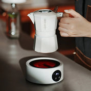 Elektrischer Kaffeewärmer in Weiß erhitzt eine Mokkakanne in der Anwendung